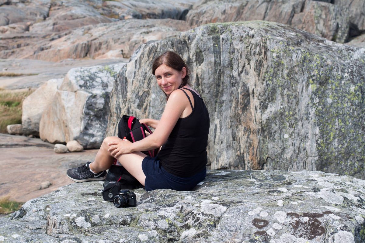 Sarah sits in front of some beautiful, multi-coloured granite. Take a walk with Sarah on Hönö with Meet the Locals
